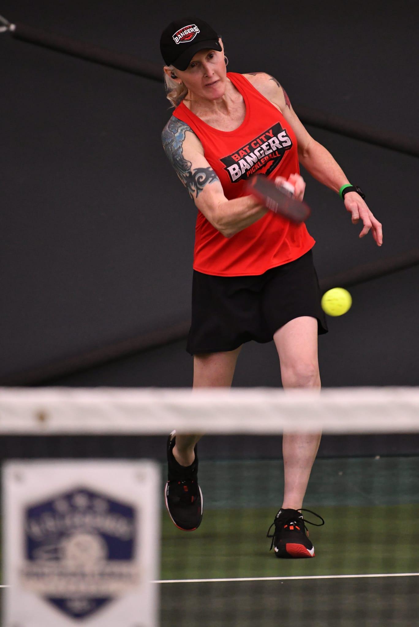 Madeline Eden firing a forehand at the net